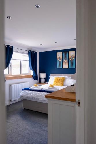 a bedroom with a bed with blue walls and a desk at Number 9 in Fort William