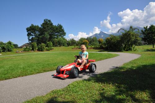 a young child riding a toy car on a path at Karglhof Stammhaus in Faak am See