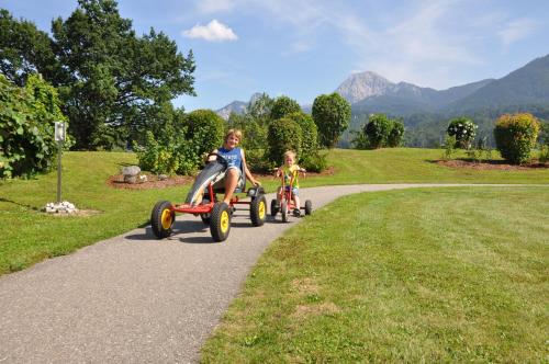 two children riding on tricycles down a path at Karglhof Stammhaus in Faak am See