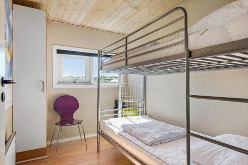 a bedroom with two bunk beds and a chair at 8585-Glesborg-Tangvej-33 in Glesborg