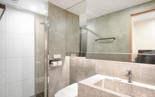 ein Badezimmer mit Waschbecken und Dusche in der Unterkunft Urban Brown Hotel in Gunsan