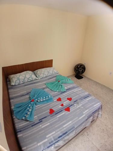 a bed with blue sheets with hearts on it at Aconchego Ebenézer in Praia de Provetá 
