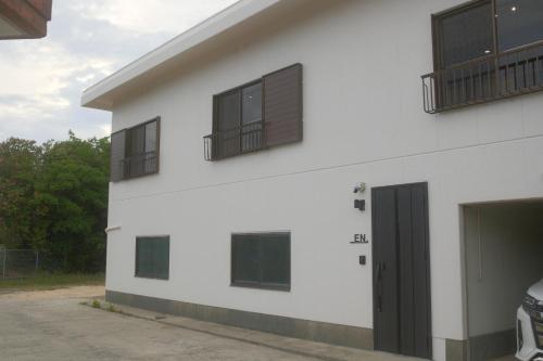 a white building with windows and a door at Private Stay EN SUMOTO in Sumoto