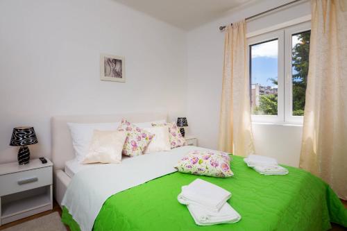 een slaapkamer met een groen bed en een raam bij APARTMENT "Patricia" in Split