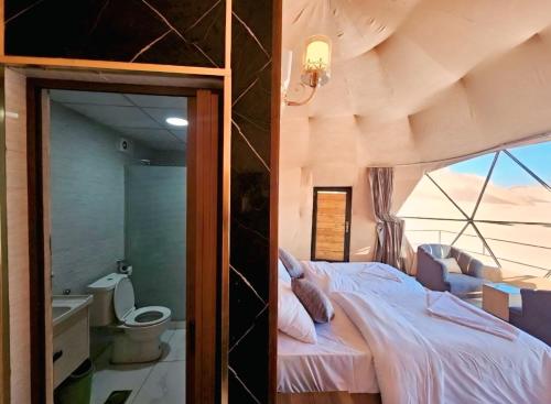 a bedroom with a bed and a large window at Wadi Rum Elara Luxury Camp in Wadi Rum