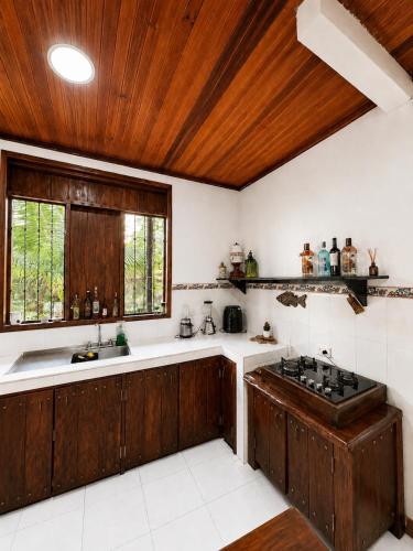 a kitchen with wooden cabinets and a sink at La Cabaña Mr Brown in Puerto Leguízamo