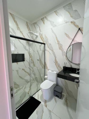 a bathroom with a toilet and a sink and a mirror at Casa de hospedagem e lazer in Sao Jose do Rio Preto