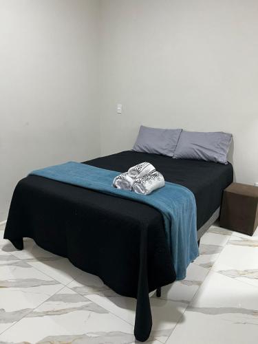 a bed in a room with a blue blanket on it at Casa de hospedagem e lazer in Sao Jose do Rio Preto