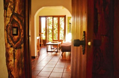 a hallway with a room with a table and a door at San Pedro in Ráquira