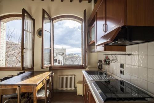 サン・ジミニャーノにあるラ ロカンダ ディ クエルチェッキオの窓2つとカウンタートップ付きのキッチン