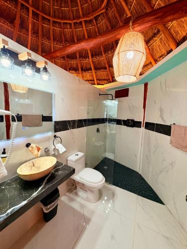 a bathroom with a sink and a toilet at Cabanas Jaalkab in Chelem