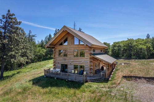a log cabin in the middle of a field at Adams Rest Cabin in The Dalles