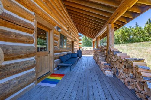 a porch of a log cabin with a bench and logs at Adams Rest Cabin in The Dalles