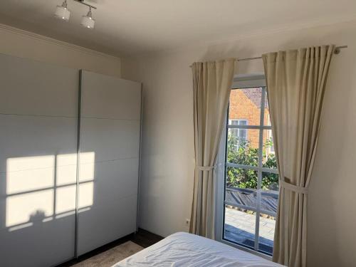 a bedroom with a bed and a large window at Grodehus-Eigener-Bungalow in Haby