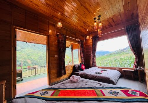 a bedroom with two beds and a large window at TaVan Eco Home in Tả Van
