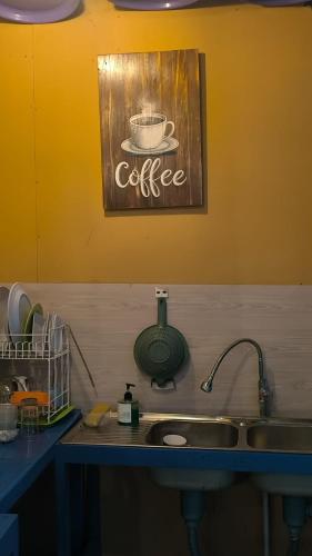a kitchen sink with a picture of a cup of coffee at A-Manta Homestay in Labuan Bajo