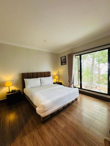 ein Schlafzimmer mit einem großen Bett und einem großen Fenster in der Unterkunft On Cloud Resort in Murree