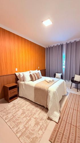 a bedroom with a large bed and a wooden wall at Suíte Ipê-Amarelo in Camanducaia