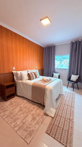 a bedroom with a large bed with a rug at Suíte Ipê-Amarelo in Camanducaia