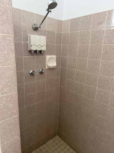 a bathroom with a tiled shower with a toilet at Wattle Tree Motel in Cootamundra