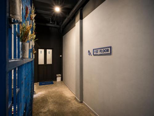 a hallway with a first floor sign on a wall at Loftel Station Hostel in Bangkok