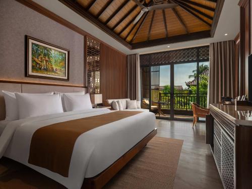 a bedroom with a large bed and a balcony at MĀUA OLEA Ubud by Swiss-Belhotel in Ubud