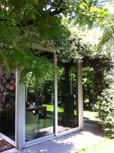 a glass house with a table in a garden at La Mansarda di Margherita in Treviso