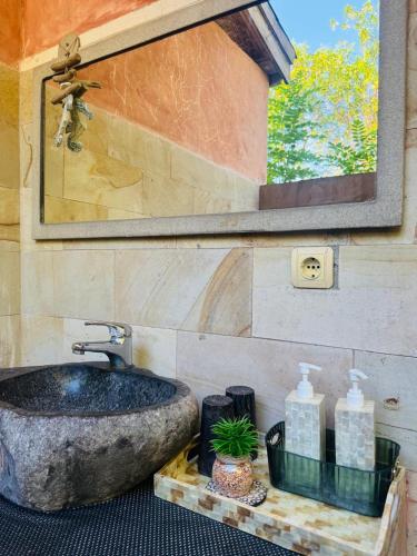 a bathroom with a large stone sink and a mirror at Villa Sea La Vie Private pool in Gili Meno