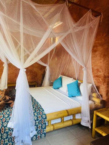 a bedroom with a bed with a mosquito net at Villa Sea La Vie Private pool in Gili Meno
