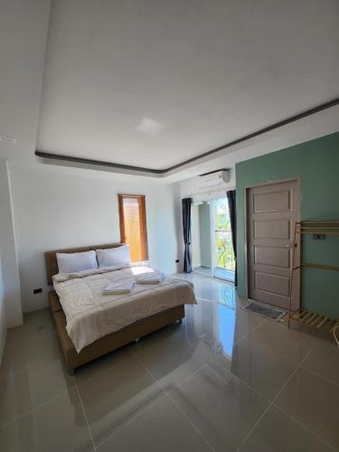 a bedroom with a large bed and a door at The wishes สมหวัง in Si Sa Ket