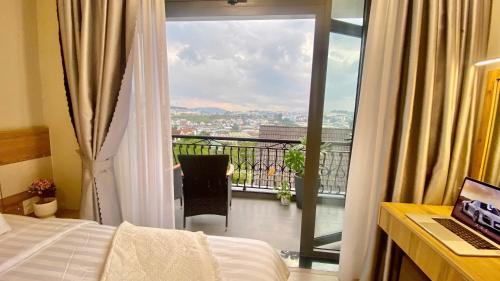 a hotel room with a bed and a balcony with a view at Minh An Villa in Da Thanh