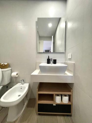 a white bathroom with a sink and a mirror at Del Pino Park in Buenos Aires