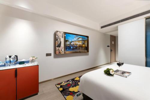 a room with a table and a painting on the wall at Insail Hotels Guangzhou Beijing Road Pedestrian Branch in Guangzhou