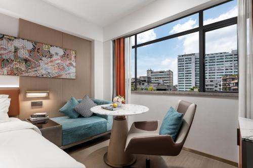 a hotel room with a bed and a table and a couch at Insail Hotels Guangzhou Beijing Road Pedestrian Branch in Guangzhou