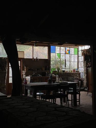 a living room with a table and chairs and windows at Refugio La Paciencia in Travesía