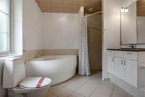 a bathroom with a tub and a toilet and a sink at C11068-Hemmet-Vibevaenget-11 in Hemmet