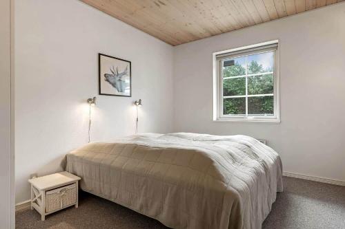 a white bedroom with a bed and a window at C11068-Hemmet-Vibevaenget-11 in Hemmet