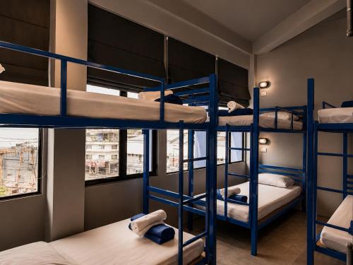a room with four bunk beds in a hostel at Loftel Station Hostel in Bangkok