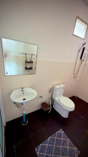 a bathroom with a sink and a toilet and a mirror at The Canal Hut Chaloklum in Chaloklum