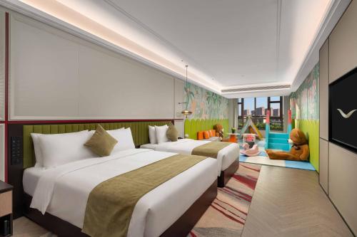 two beds in a room with two children sitting on a rug at Mövenpick Kaifeng West Lake in Kaifeng