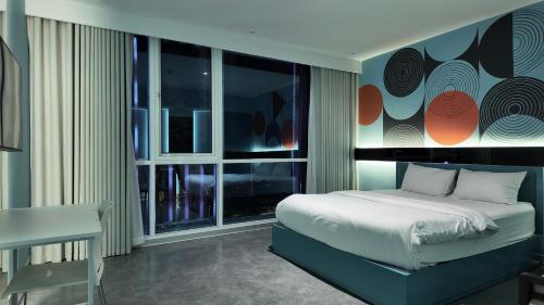 a bedroom with a bed and a large window at J Village Hotel - Triệu Việt Vương in Hanoi