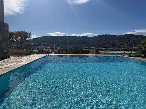 a large blue swimming pool with mountains in the background at Skiathos Seaview Villa with Pool in Punta