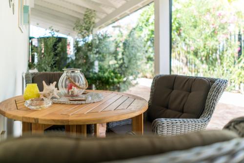 una mesa en un porche con un jarrón de cristal. en Cas Elizabeth, en Palm-Eagle Beach
