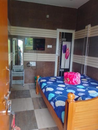 a bedroom with a bed with a blue comforter at UP enterprices in Yercaud