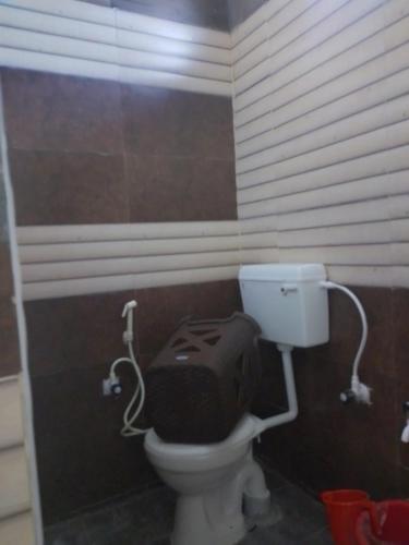 a bathroom with a toilet with a bag on the seat at UP enterprices in Yercaud