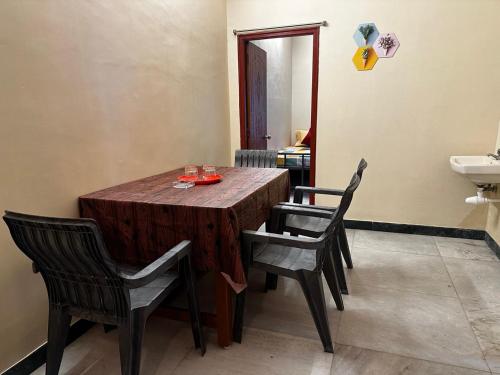a wooden table with chairs and a sink in a room at IP Home stays in Pondicherry