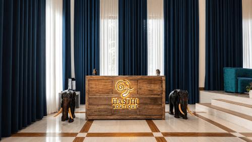 two elephants standing behind a podium in a room at Hasthi Boutique in Kandy