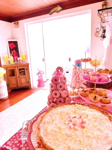 a table topped with pies and pastries in a room at Pink Village Boutique in Campos do Jordão