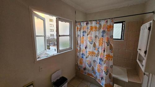 a bathroom with a shower curtain and a window at HOSTEL Gloria Economy in Viña del Mar