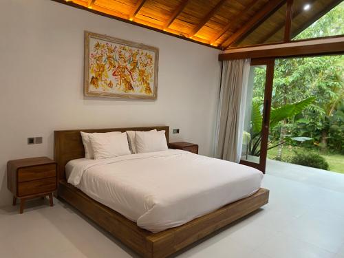 a bedroom with a bed and a large window at Antav Mesare Villa in Payangan